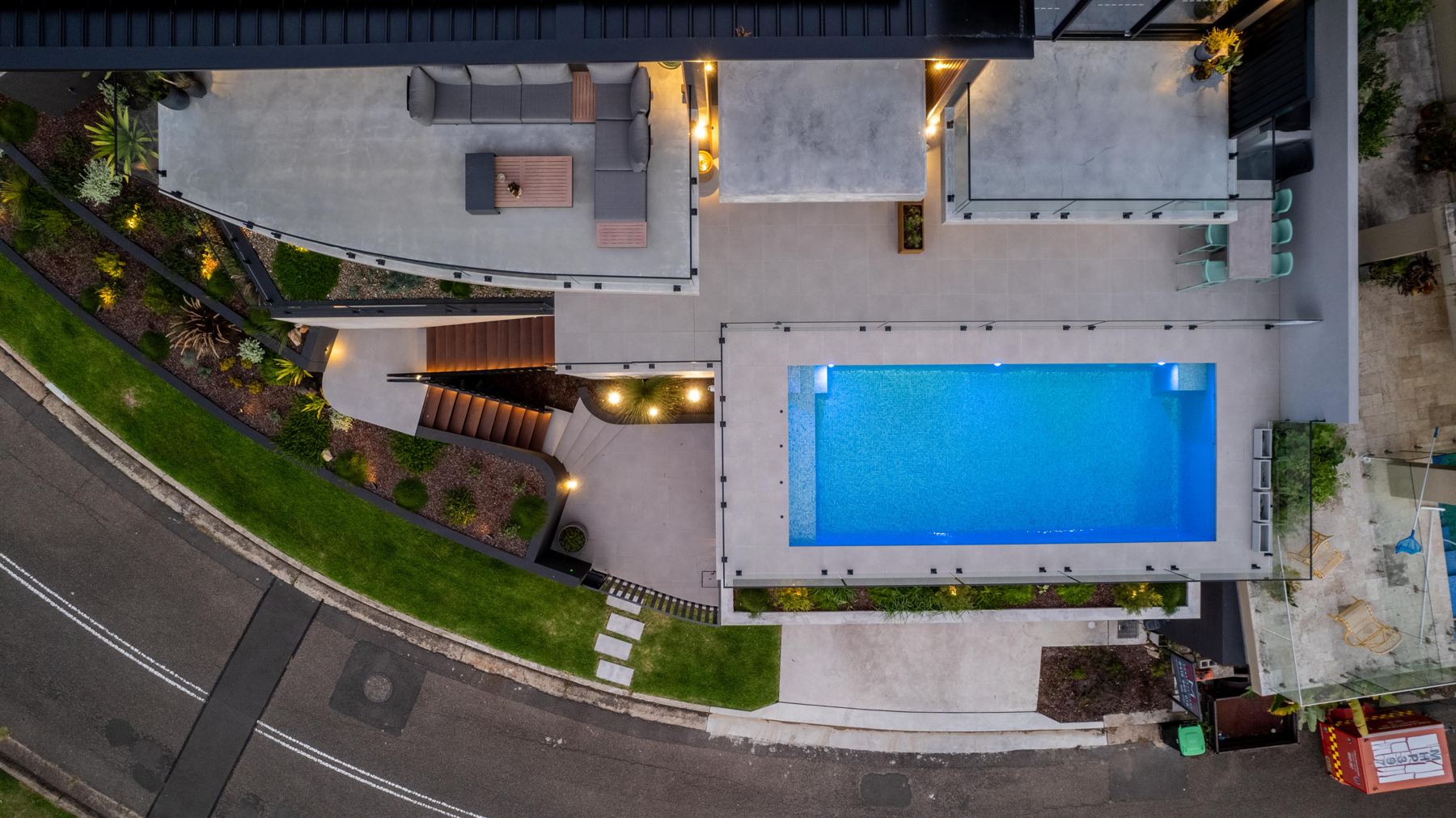 Top-down view of pool, stairs and garden lighting at dusk